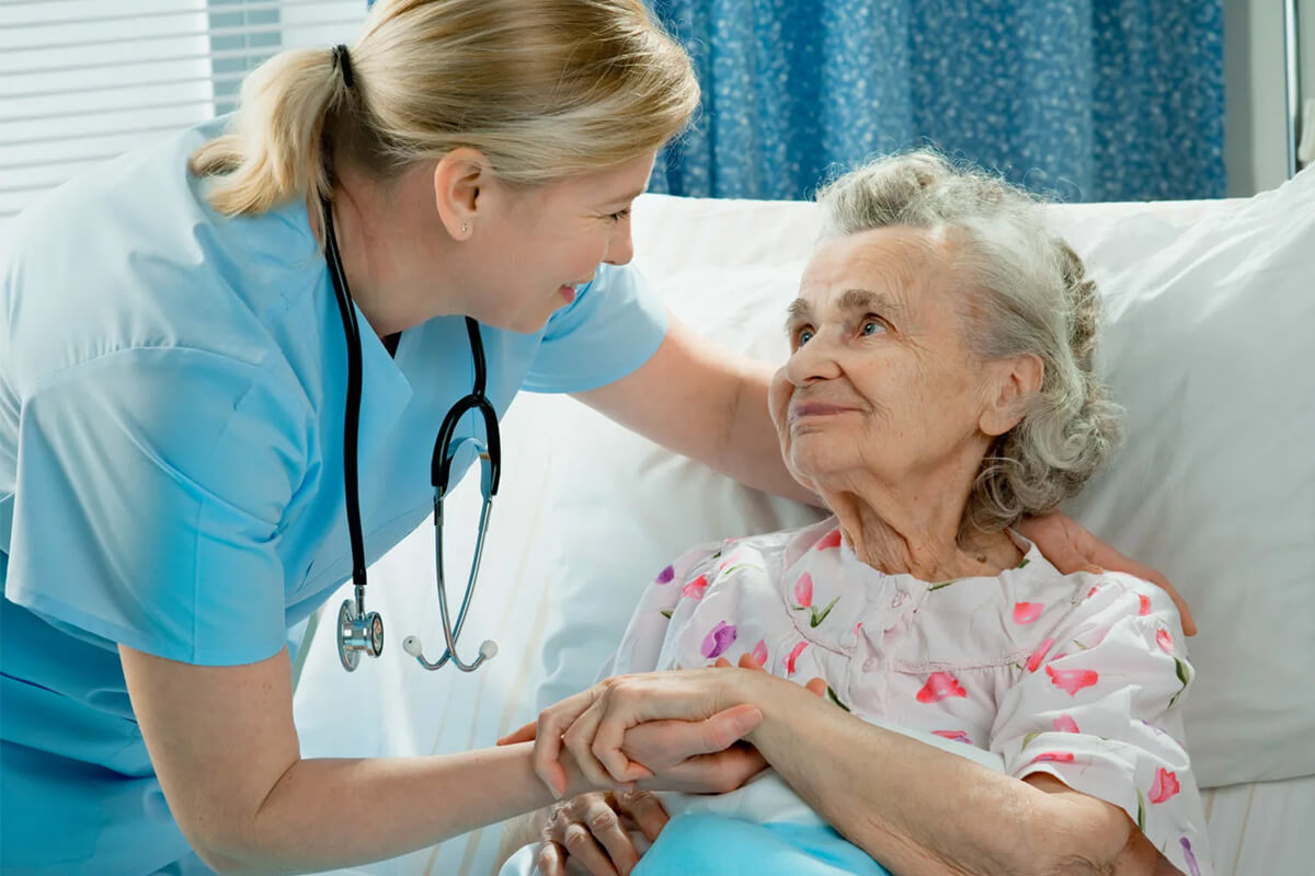 Врач-кардиолог (она) держит за руку бабушку