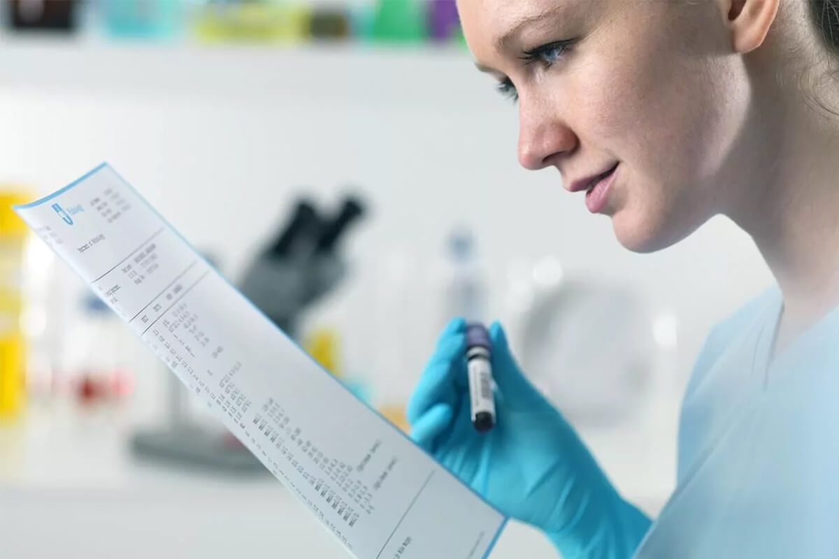 Девушка-врач смотрит расшифровку по онкомаркеру